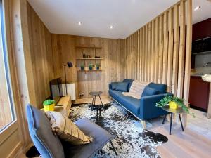 - un salon avec un canapé bleu et des murs en bois dans l'établissement Appartement Morzine, 3 pièces, 4 personnes - FR-1-627-64, à Morzine