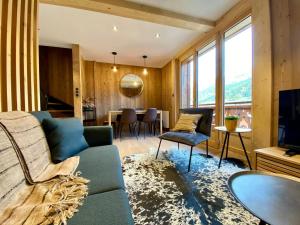 - un salon avec un canapé bleu et une table dans l'établissement Appartement Morzine, 3 pièces, 4 personnes - FR-1-627-64, à Morzine