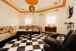 uma sala de estar com um sofá e um piso xadrez em résidence qarya syahia private roof terrasse em Marraquexe