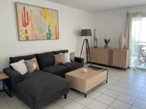 a living room with a couch and a coffee table at Zabana Lodge, dans un jardin tropical avec piscine in Saint-Claude