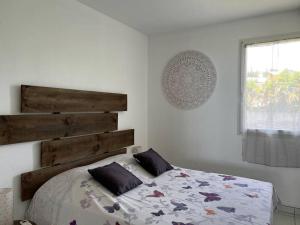 sypialnia z łóżkiem z drewnianym zagłówkiem w obiekcie Zabana Lodge, dans un jardin tropical avec piscine w mieście Saint-Claude