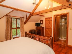 a bedroom with a bed and a window at Stone Barn in Holsworthy