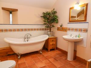 a bathroom with a tub and a sink at Stone Barn in Holsworthy +25 photos
