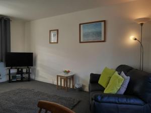 a living room with a couch and a flat screen tv at Cliffwalk Cottage in Portland