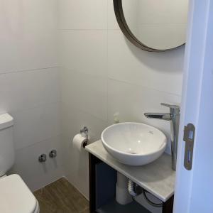 een badkamer met een wastafel, een toilet en een spiegel bij Depto. Con vista al mar a estrenar in Mar del Plata