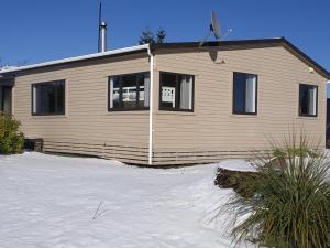 a house that is sitting in the snow at Tongariro Estate in National Park