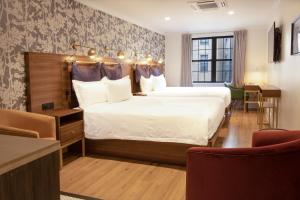a hotel room with two beds and a table and chairs at Hotel Scherman in New York