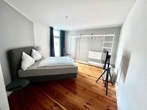 sypialnia z łóżkiem i drewnianą podłogą w obiekcie Cityapartments Düsseldorf - Stresemannstraße w mieście Düsseldorf
