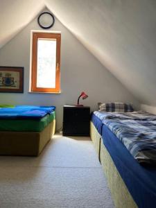 a attic bedroom with two beds and a window at Planinska kuća na Velebitu, s pogledom na more in Veliki Alan