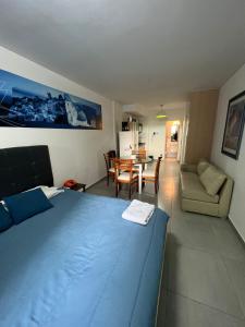 1 dormitorio con 1 cama azul y sala de estar en 8M Monoambiente nuevo en el Centro de Rosario p 2 personas en Rosario