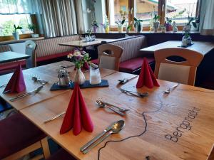 uma mesa de madeira com guardanapos vermelhos em cima em Pension Bergpracht em Ramsau am Dachstein