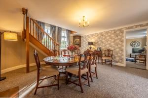 een eetkamer met een tafel en stoelen bij Maltings Lodge in Chelsworth