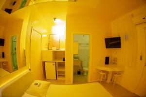 a yellow room with a bed and a bathroom at Motel Nix in Santa Maria +55 photos