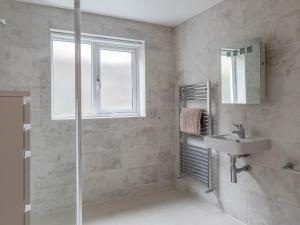 a bathroom with a shower and a sink and a mirror at Welsummer in Salcombe