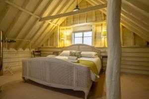 a bedroom with a large white bed in a attic at The Barns at Green Valley Farm in Heveningham