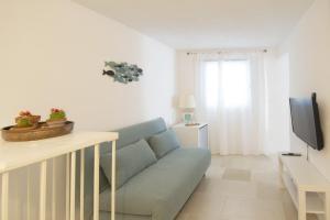 un soggiorno con divano blu e TV di A Casa di Elena a Polignano a Mare