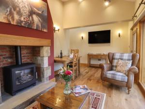 a living room with a fireplace and a television at Ash Cottage in Skipton