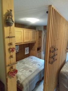 - une petite chambre avec un lit et des placards en bois dans l'établissement cimes d'or, aux Contamines-Montjoie