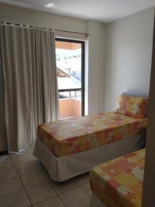 1 dormitorio con 2 camas y ventana con vistas en Residencial Com. Dória, en Bombinhas