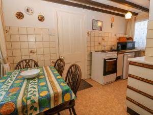 a kitchen with a table and chairs and a kitchen with a stove at Brig Y Don in Caernarfon