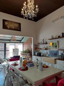 uma cozinha com uma mesa com cadeiras e um lustre em Aristobulo em Buenos Aires