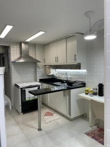uma cozinha com um fogão e uma bancada em Charmoso apartamento no melhor ponto de Ipanema no Rio de Janeiro