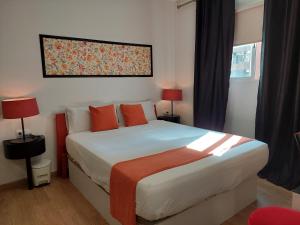 ein Schlafzimmer mit einem großen Bett mit orangefarbenen Kissen in der Unterkunft Apartamentos Rous - Solo adultos in Valencia