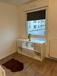 Kleines Zimmer mit einem Schreibtisch und einem Fenster in der Unterkunft Studio Cosy et Charmant au cœur de Saint Cyr in Saint-Cyr-lʼÉcole