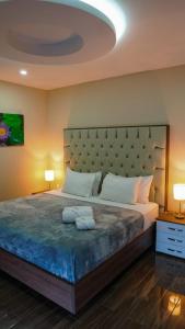 um quarto com uma cama grande e uma grande cabeceira. em THE VIEW HOTEL em Cumanda