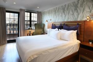 a bedroom with a large white bed and a chair at Hotel Scherman in New York