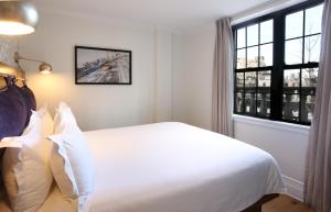 a bedroom with a white bed and a window at Hotel Scherman in New York
