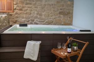 a bath tub with a table and wine glasses at La Casona de Alútiz & Bodega in Samaniego