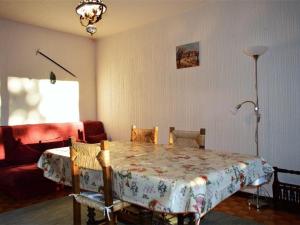 a living room with a table and a red couch at Appartement Font-Romeu-Odeillo-Via, 3 pièces, 6 personnes - FR-1-580-32 in Font-Romeu-Odeillo-Via
