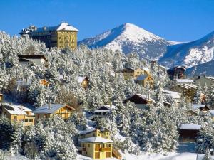 a village covered in snow with a mountain in the background at Appartement Font-Romeu-Odeillo-Via, 3 pièces, 6 personnes - FR-1-580-32 in Font-Romeu-Odeillo-Via