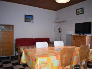 ein Esszimmer mit einem Tisch mit Stühlen und einem Flachbild-TV in der Unterkunft Appartement Font-Romeu-Odeillo-Via, 2 pièces, 4 personnes - FR-1-580-41 in Font Romeu Odeillo Via