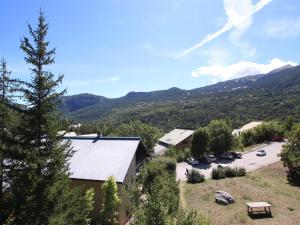 einen Blick über ein Gebäude mit Parkplatz und Berge in der Unterkunft Appartement Vallouise, 1 pièce, 4 personnes - FR-1-330G-126 in Puy-Saint-Vincent