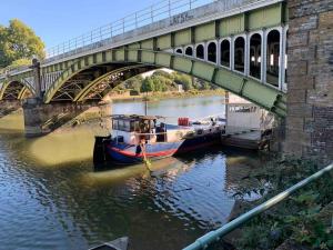 un barco está atracado en el agua bajo un puente en Flat Near Richmond Upon Thames, en Richmond