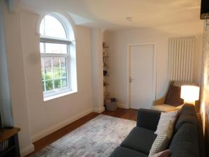 a living room with a couch and a window at Delfryn Holiday Cottage in Colwyn Bay