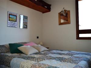 ein Schlafzimmer mit einem Bett mit Kissen darauf in der Unterkunft Appartement Font-Romeu-Odeillo-Via, 2 pièces, 6 personnes - FR-1-580-30 in Font Romeu Odeillo Via