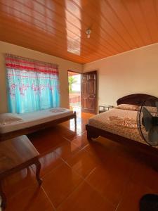 a bedroom with a bed and a wooden ceiling at Cabinas Las Palmas del Sol in Fortuna