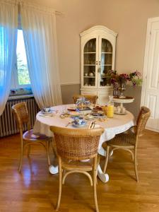 een eettafel met een wit tafelkleed en stoelen bij MANZONI37 in Novi Ligure