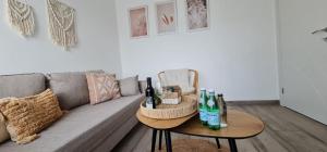 a living room with a gray couch with bottles on a table at קסם של אירוח in Hagoshrim