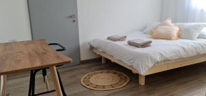 哈戈什里姆קסם של אירוח的一间卧室配有一张带白色床单和木桌的床。