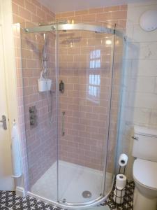 y baño con ducha y puerta de cristal. en Delfryn Holiday Cottage en Colwyn Bay