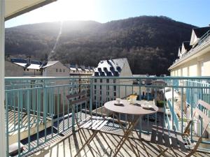 a balcony with a table and a view of a mountain at Appart. central 6/7 pers. à Bagnères-de-Luchon avec parking et animaux admis - FR-1-313-171 in Luchon +6 photos