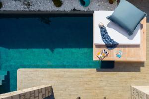 an overhead view of a swimming pool with a chaise lounge at Southrock Villas in Lachania
