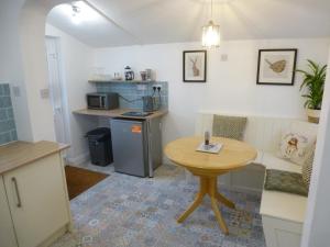 uma cozinha com uma mesa e uma pequena mesa e um quarto em Delfryn Holiday Cottage em Colwyn Bay
