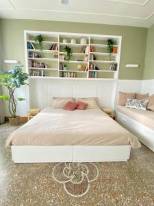 1 dormitorio con cama blanca y estanterías en La Casa di Miele - Center Rome apartment, en Roma