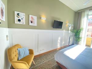 1 dormitorio con 1 cama, 1 silla y TV en La Casa di Miele - Center Rome apartment, en Roma
