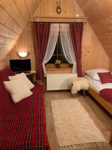 ブコビナ・タトシャンスカにあるSkalnica Pokoje Gościnneの屋根裏のベッドルーム(ベッド2台、窓付)